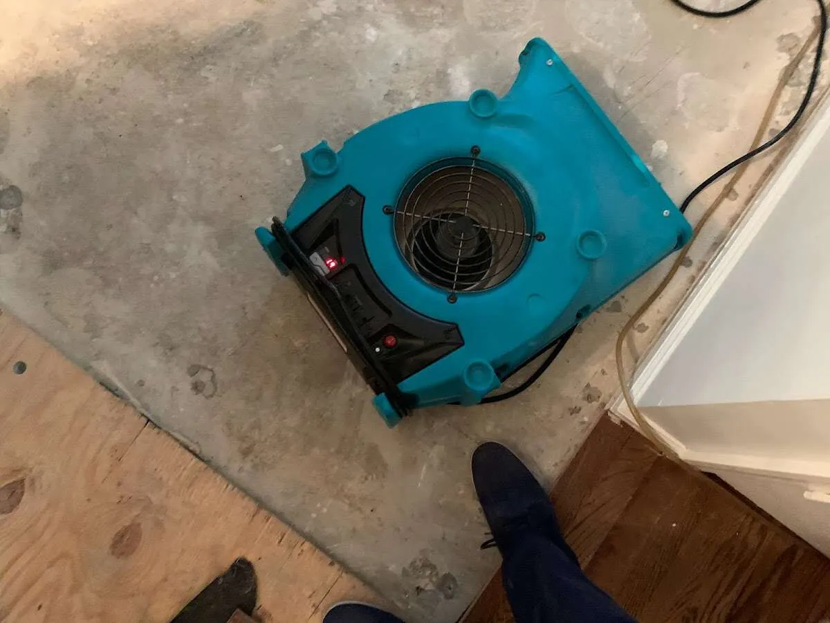 Air mover drying subfloor during Commercial Water Damage Restoration in Monfort Heights